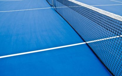 An empty blue outside tennis court and net.